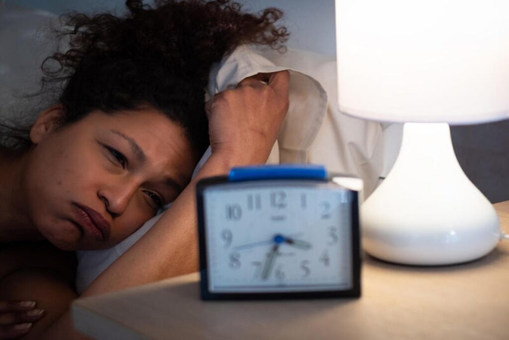 Software engineer working late at night while chronic sleep deprivation affects heart health