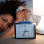 Software engineer working late at night while chronic sleep deprivation affects heart health