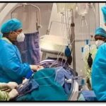 Cardiologist performing TAVI procedure for a senior patient with aortic stenosis using minimally invasive valve replacement technology.