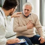 Cardiologist reviewing real-time heart monitoring data from wearable devices on a digital dashboard for remote patient care